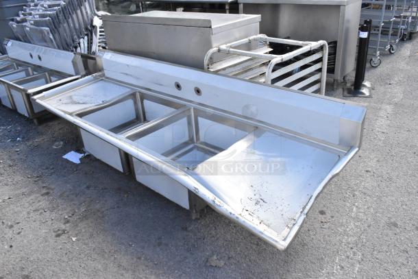 BRAND NEW Scratch and Dent Regency 600S22323224 stainless steel 2 bay sink with dual drain boards, minor surface damage visible.