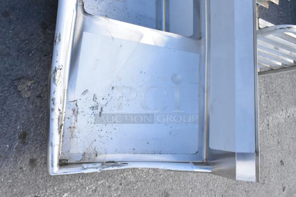 Brand new Regency 600S22323224 stainless steel 2 bay sink with visible scratches and dents, featuring dual drain boards.