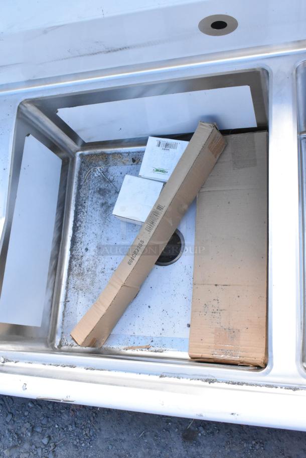 BRAND NEW SCRATCH AND DENT! Regency 600S22323224 stainless steel 2 bay sink with dual drain boards, visible dirt and wear.