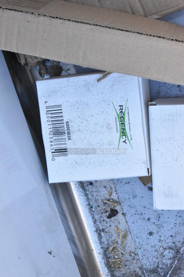 BRAND NEW SCRATCH AND DENT Regency 600S22323224 stainless steel 2-bay sink with dual drain boards, visible packaging.