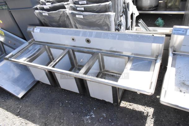 New Regency 600S31416212 stainless steel 3 bay sink with dual drain boards, no legs, scratch and dent condition.