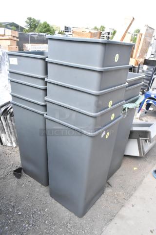Brand new gray poly trash cans, scratch and dent condition, stacked outdoors. Visible labels indicate inventory tags.