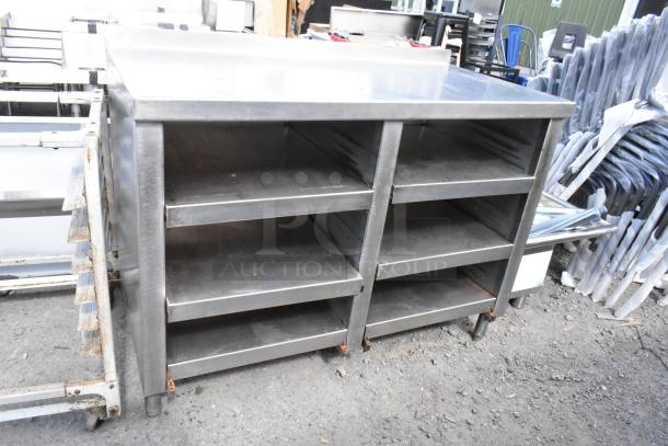 Stainless steel table with under shelves, featuring a durable industrial design. Ideal for kitchens or workshops.