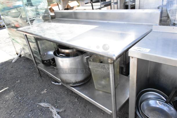 Stainless steel table with under shelf, includes skillets and stock pots. Excellent condition, sturdy, ideal for kitchen use.