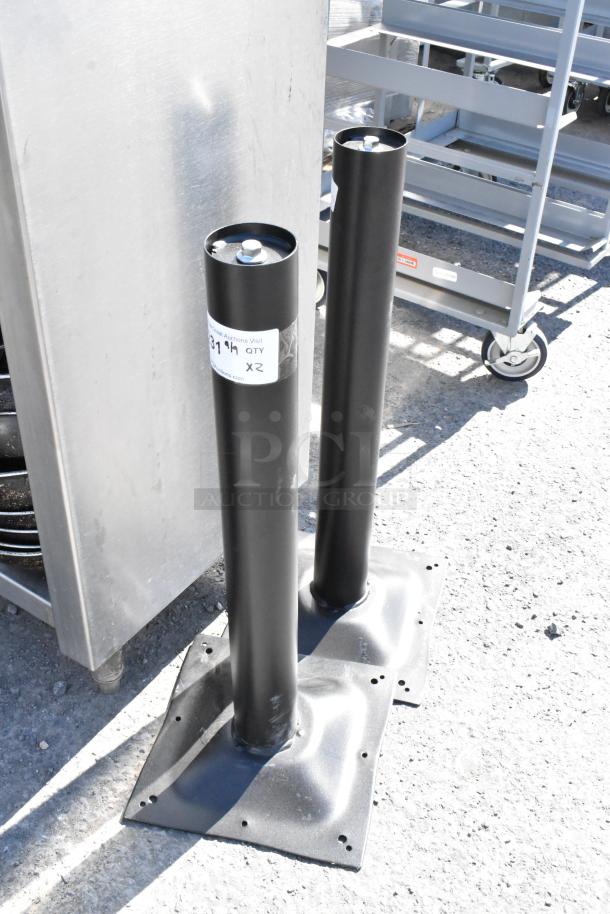 Two black metal table base columns with square mounting plates, lightly scuffed, each tagged "QTY X2." Suitable for sturdy table construction.