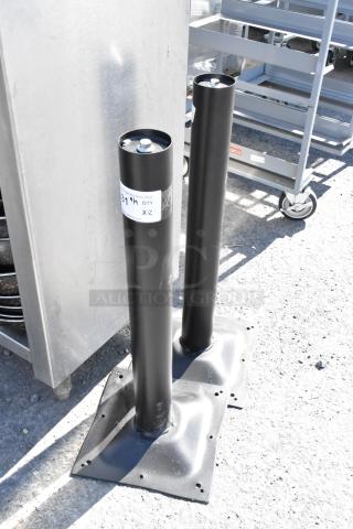 Two black metal table base columns with square mounting plates, lightly scuffed, each tagged "QTY X2." Suitable for sturdy table construction.