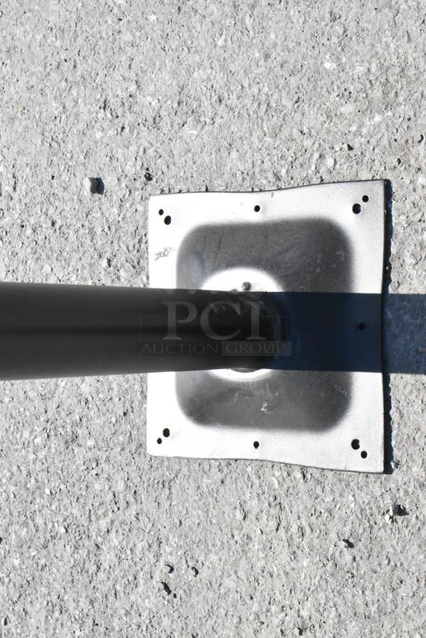 2 black metal table base columns, square mounting plate, sturdy condition, ideal for commercial use.