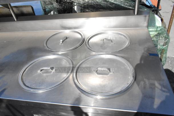 Belshaw stainless steel commercial prep station with over shelf, drawers, under shelf, and commercial casters. Features four circular lids.