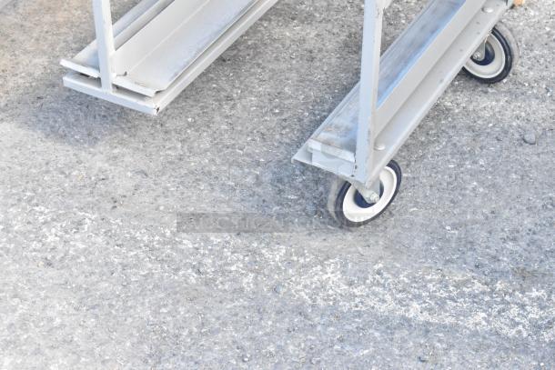 Metal double transport rack on commercial casters, showing sturdy construction and durable wheels for easy mobility.