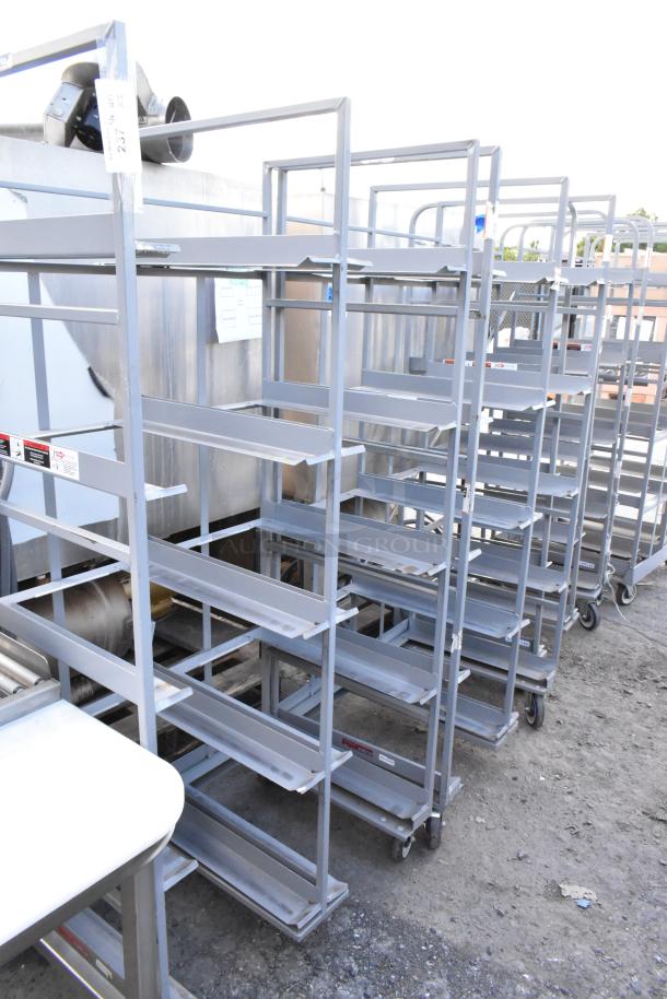 2 metal double transport racks on commercial casters. Sturdy construction, multiple shelves, and industrial wheels for mobility.