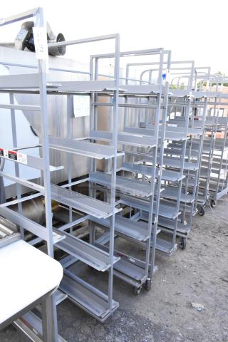 2 metal double transport racks on commercial casters. Sturdy construction, multiple shelves, and industrial wheels for mobility.