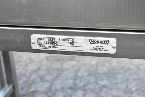 Hobart HRT5 stainless steel commercial roller conveyor wrapping station with visible model, suffix, and serial number label.