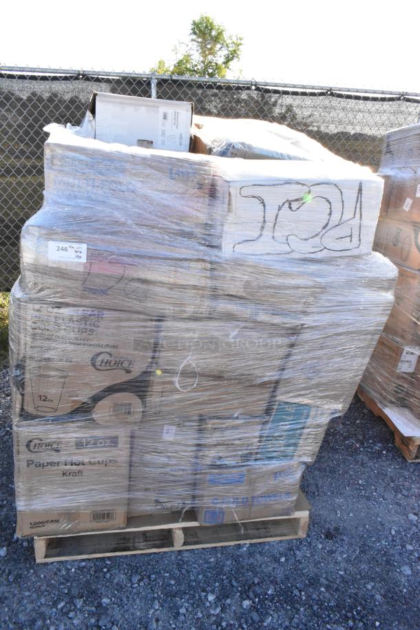 Shrink-wrapped pallet of assorted new scratch and dent items, including cold cups, towels, baking cups, on gravel surface.