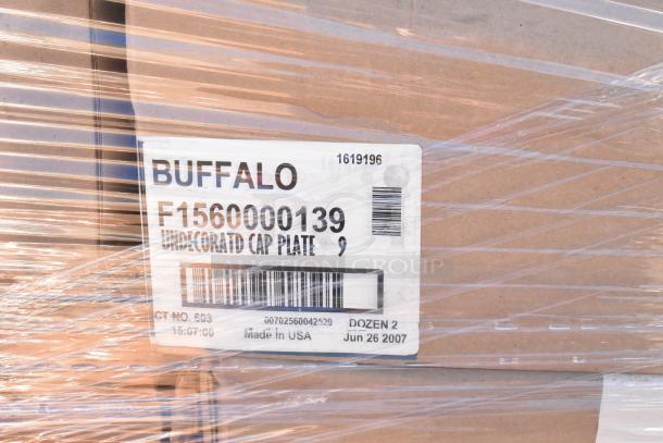 Cardboard box labeled “BUFFALO F1560000139 Undecorated Cap Plate,” wrapped in clear plastic, contains new glassware.