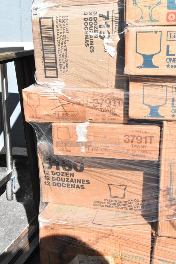 Boxes of new Libbey glassware, labeled for various types and quantities, showing scratch and dent condition.