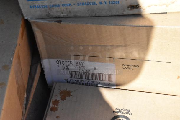 Boxes of Oyster Bay plates labeled "SYR 9 3/4" Plate 1 Dozen," from Syracuse China Corp, visible tags.