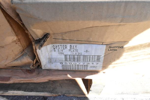 Worn packaging with a shipping label for Oyster Bay 9 3/4" plates, 1 dozen. Scratch and dent condition visible.