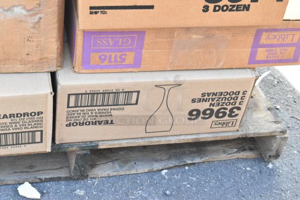 Cardboard boxes labeled "Libbey 3 dozen glasses" on a pallet. New items, some marked "scratch and dent."