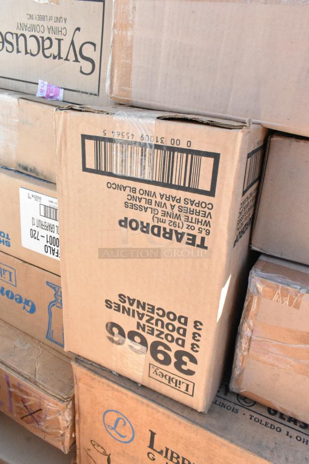 Boxes of scratch and dent dishware items. Includes Libbey and Syracuse brands. Labels indicate glass and china contents.