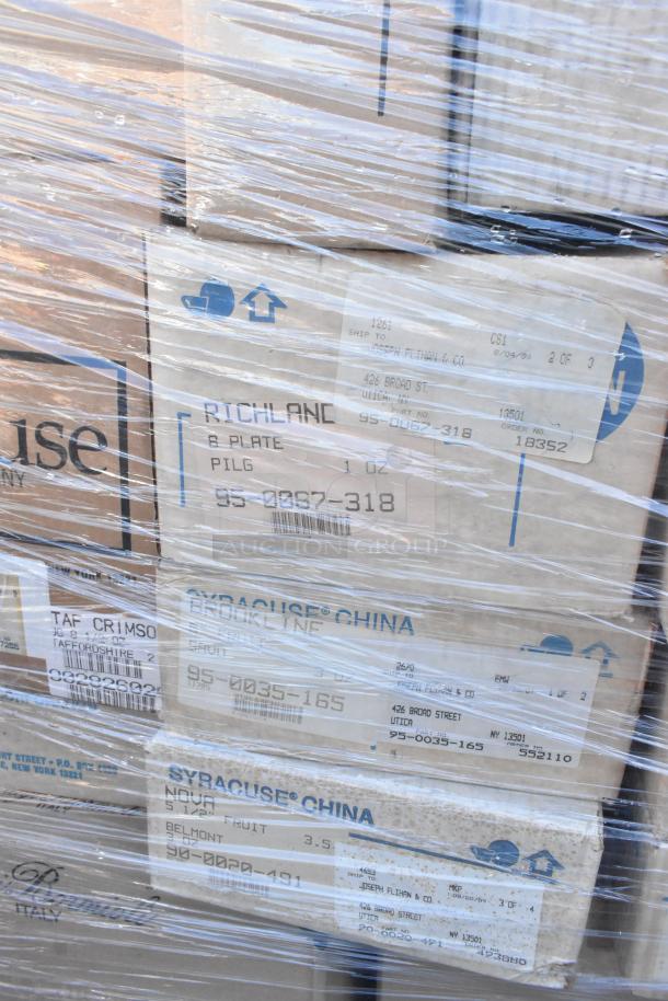 Boxes of new scratch and dent dishware/glassware wrapped in plastic. Labels indicate brands like Syracuse China.