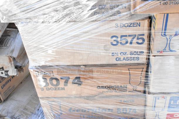 Boxes of scratch and dent glassware, labeled "3 dozen," featuring 5¼ oz. sour glasses and parfait glasses, wrapped in plastic.