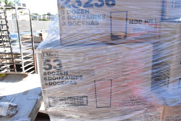 Auction items including 54 boxes of Libbey glassware, with labeling indicating various glass types. Items are brand new with minor packaging issues.