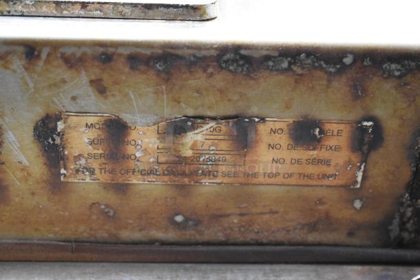 Baxter OV310G stainless steel commercial rack oven, serial number visible, shows heavy wear and rust on label plate.
