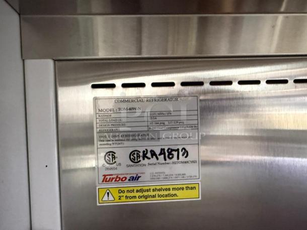 Turbo Air TOM-40W-N 39" white refrigerated merchandiser label. Shows model, specs, and warning about shelf adjustment.
