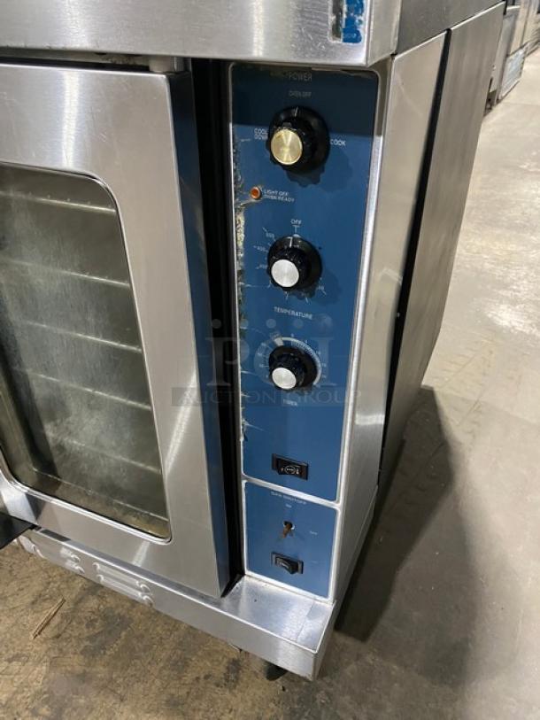 Duke Manufacturing stainless steel double-stacked convection oven, natural gas, thermostatic controls, wire racks, on casters.