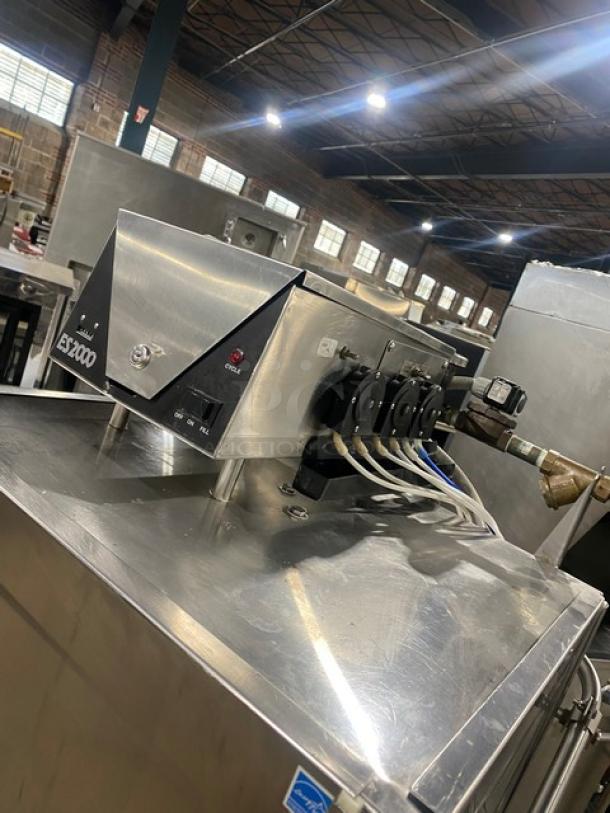 Commercial stainless steel dishwasher, ES2000 model, Energy Star certified, on legs, visible control panel and wiring.