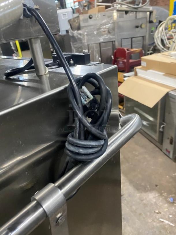 Commercial stainless steel dishwasher Model ES2000, Energy Star certified, on legs. Coiled power cord visible. Condition: appears used.