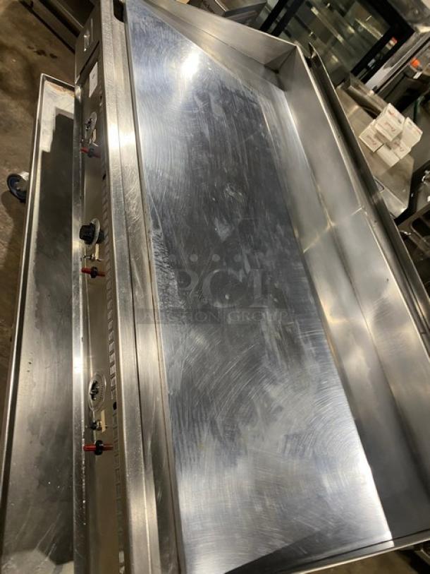Keating 60X30 stainless steel countertop griddle with back and side splash, undershelf cart, and casters. Natural gas powered.