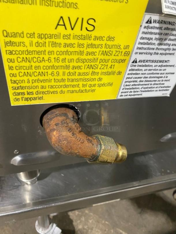 Rusty pipe connection on a Keating commercial stainless steel natural gas flat griddle, model 60X30, with safety warning labels.