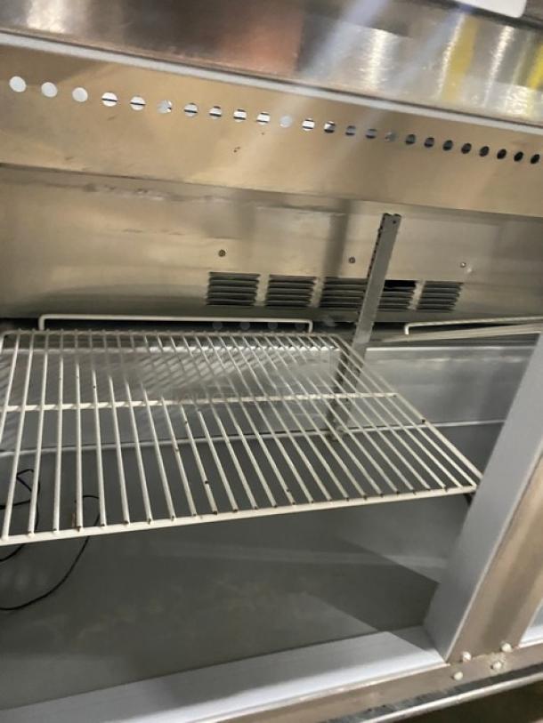 Beverage-Air SPE48HC-08 refrigerated prep table, stainless steel, 2-door, with poly coated wire racks and casters.