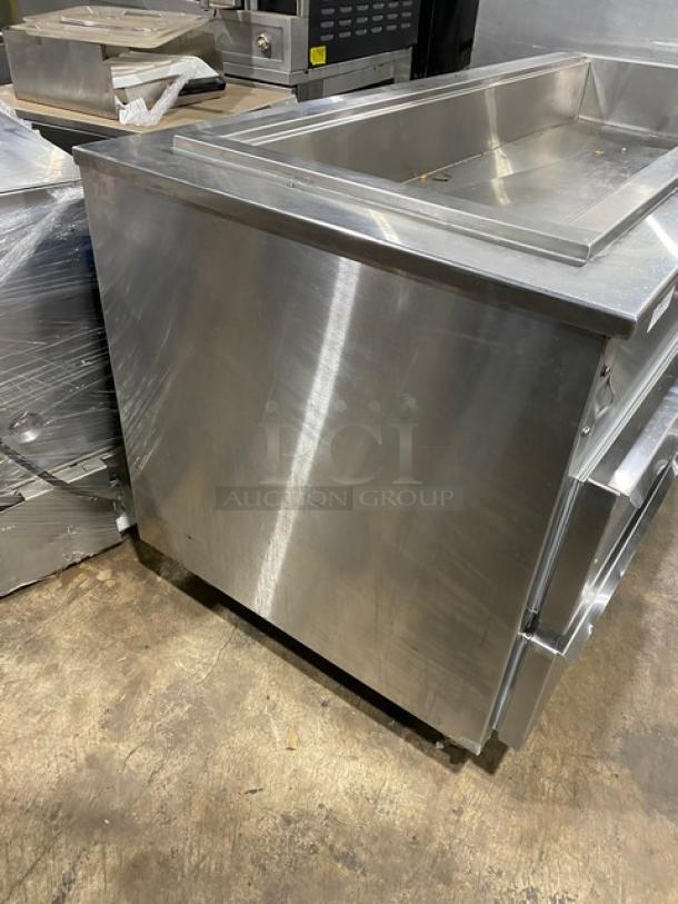 Commercial stainless steel cold pan salad bar with four drawers and casters. In good condition, ideal for restaurant use.