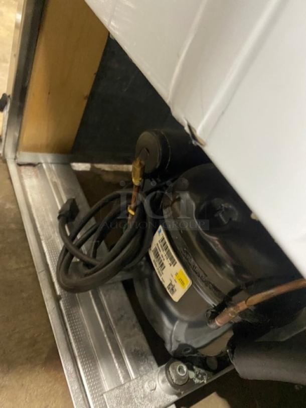 Close-up of Cooltech Commercial Refrigerated Open Grab-N-Go Merchandiser compressor, showing wiring and attached label.