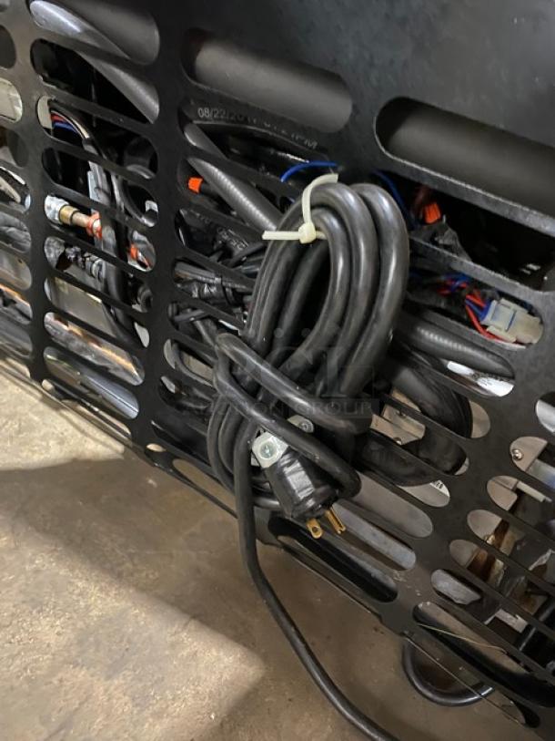 Rear of Structural Concepts Oasis Series Model B42, showing coiled power cord. Condition: used, visible metal grille.