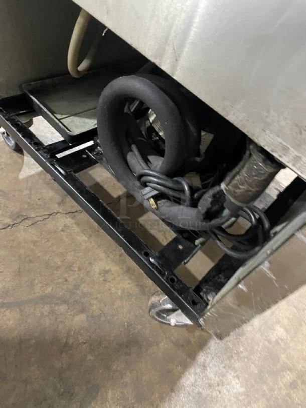 True T-23G-2 commercial refrigerator compressor area, shown with wiring and components, on casters for mobility.