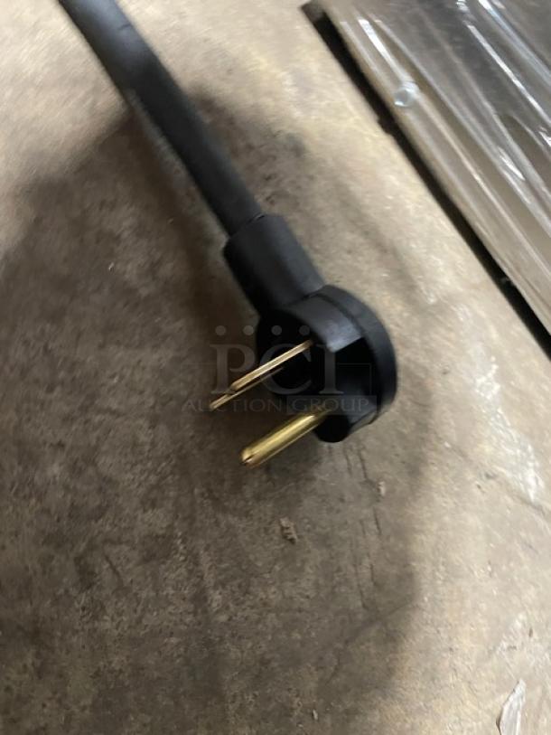 Power plug for TurboChef ENCORE2 rapid cook oven, showing a grounded three-prong design on a concrete surface.