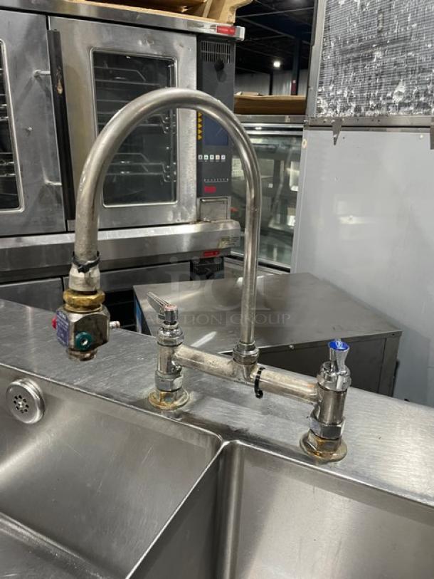 Custom commercial stainless steel double compartment sink with goose neck swivel faucet; includes enclosed cabinet base on legs.