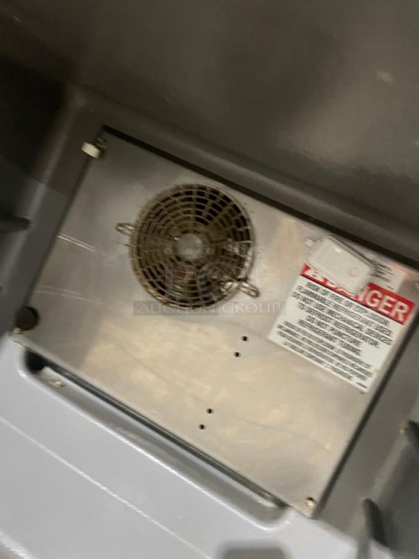 Delfield 406P-STAR2 commercial stainless steel undercounter refrigerator interior, showing fan and safety label.