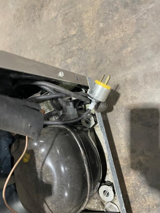 Delfield 406P-STAR2 undercounter refrigerator compressor view. Includes electrical wiring, showing 115V plug. On casters.