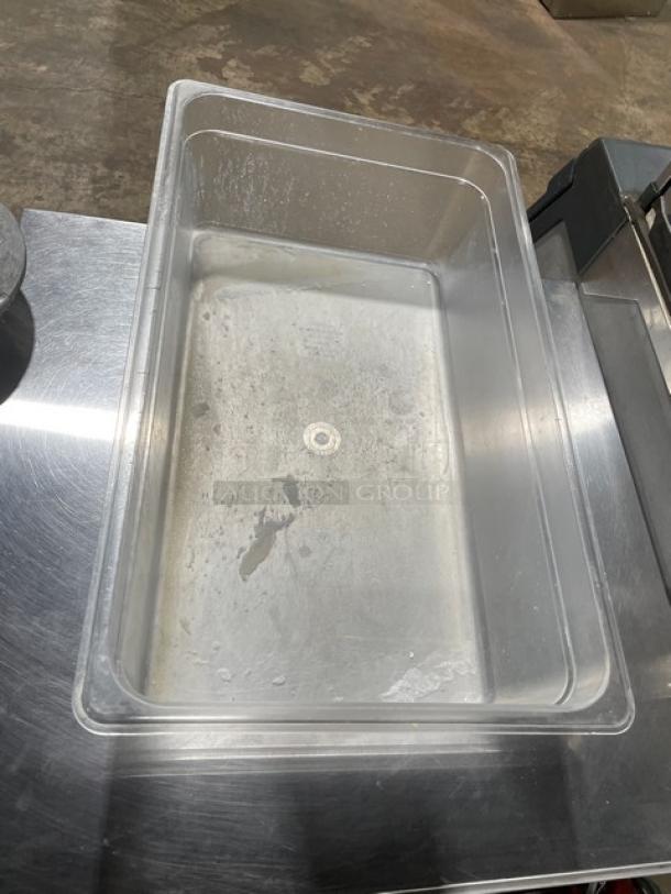 Clear polycarbonate food pan, commercial grade, rectangular shape, lightly used, sits on stainless steel surface.