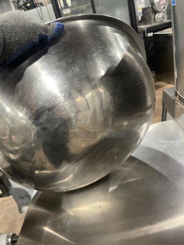 Commercial stainless steel round mixing bowl, shiny finish, light wear. Ideal for restaurant or catering use.