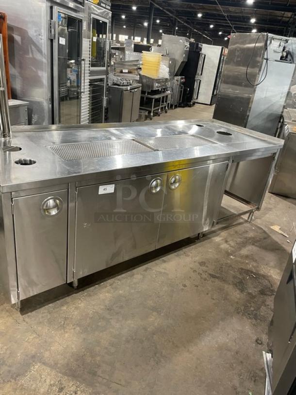 Commercial stainless steel beverage dispensing machine with double drain boards and enclosed cabinet base on legs.