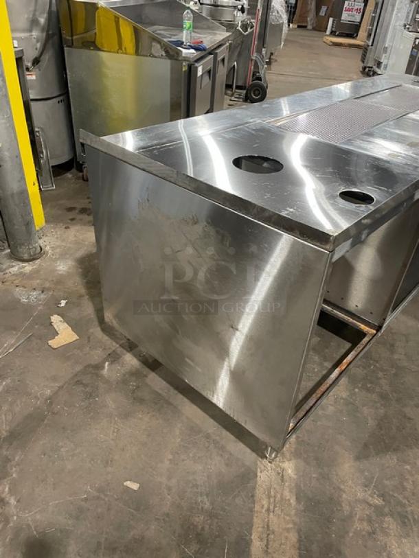 Custom commercial stainless steel beverage dispensing machine work/prep station with double drain boards, enclosed cabinet base, on legs.