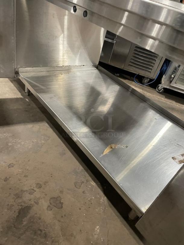 Stainless steel beverage dispensing station with double drain boards, enclosed cabinet base, and leg supports.