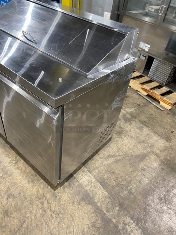 Commercial stainless steel 2-door refrigerated prep table, Model SCL2E, with poly coated wire rack on casters.