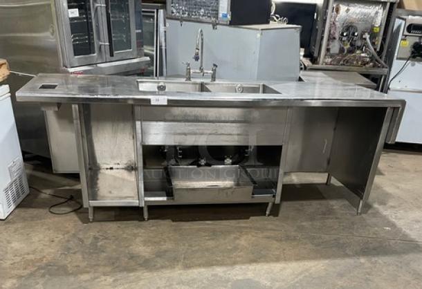 Custom commercial stainless steel double compartment sink workstation with goose neck swivel faucet and enclosed cabinet base.