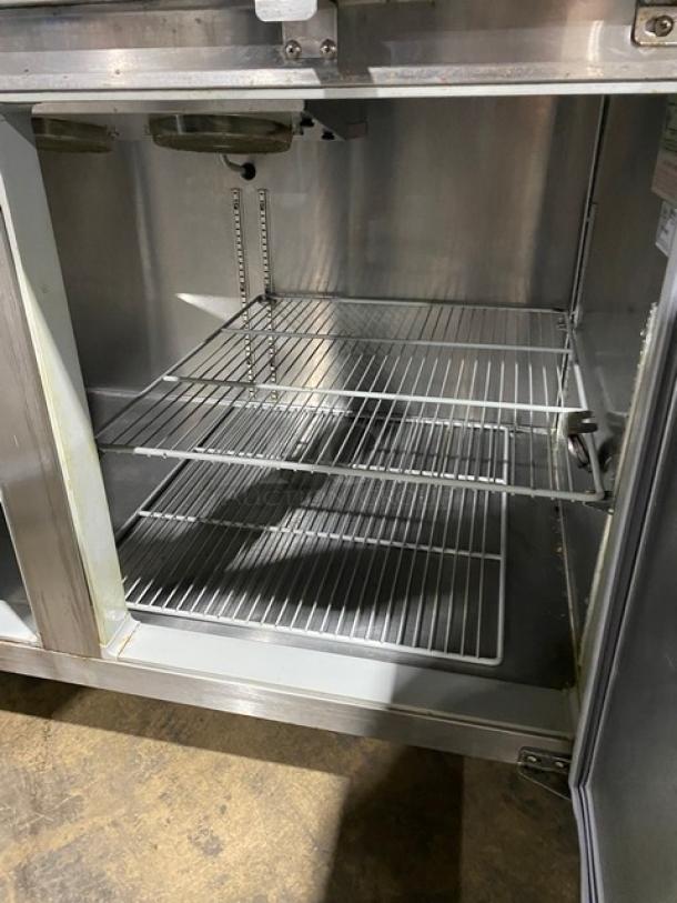 Continental CPT67-SS stainless steel 2-door refrigerated pizza prep table with poly coated wire racks, on casters.